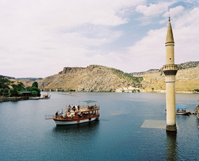 A tourist boat tour is visiting the former Savaçan Village flooded by the reservoir lake of the Birecik Dam on the Euphrates river. Turkey